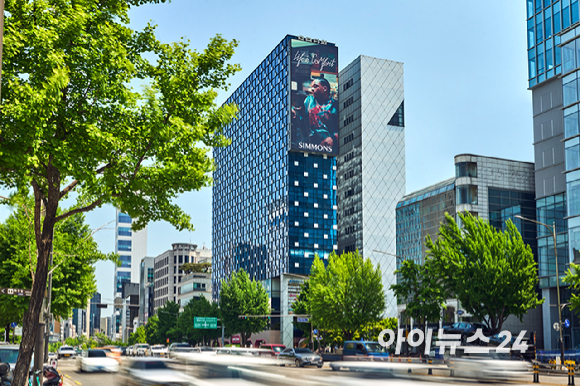 수면 전문 브랜드 시몬스가 서울 강남구 도산대로 일대에서 2026 브랜드 캠페인을 전개한다. 6일 도산대로의 고층 빌딩 사이로 신규 브랜드 캠페인 '라이프 이즈 컴포트(LIFE IS COMFORT)' 영상이 상영되고 있다. [사진=정소희 기자]