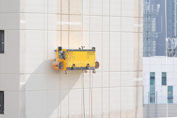 현대엔지니어링이 시공 중인 아파트 현장에서 외벽도장로봇을 시연하고 있다. [사진=현대엔지니어링 ]