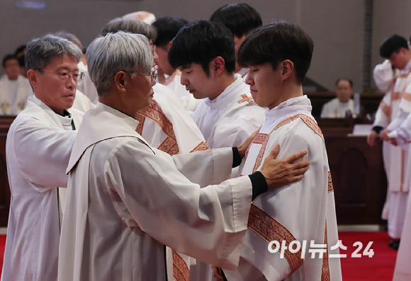 2024년 천주교 서울대교구 부제 서품식이 열린 1일 서울 중구 명동대성당에서 추천 사제들이 부제 수품자들에게 달마티카(부제복)를 입혀주고 있다. [사진=사진공동취재단]