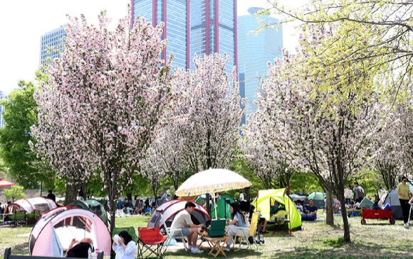 때 이른 더위가 찾아온 지난 14일 오후 서울 여의도 한강공원 나무 그늘 아래에서 시민들이 더위를 식히고 있다. [사진=뉴시스]