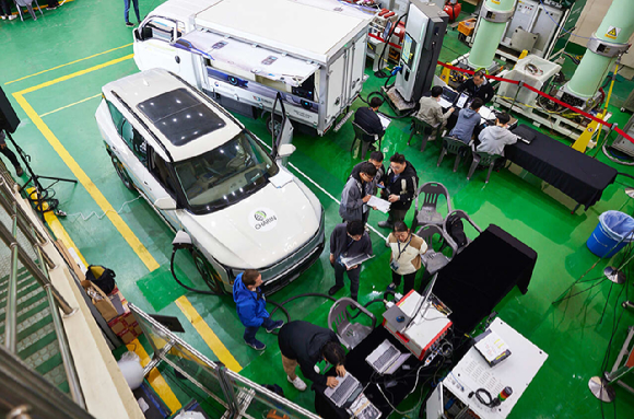 KERI가 기업 관계자들과 함께 전기차와 충전기를 교차해 상호운용성을 시험하고 있다. [사진=KERI]