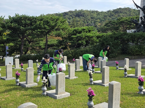 풀무원푸드앤컬처 봉사단이 국립서울현충원에서 묘역 주변 환경을 정화하는 봉사활동을 진행하고 있다. [사진=풀무원]