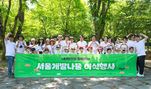 한섬 임직원과 한섬 사내 어린이집 원아, 국립생태원 멸종위기종복원센터 연구원 등 참가자들이 서울개발나물 이식행사를 마치고 기념 사진을 찍고 있다. [사진=현대백화점그룹]