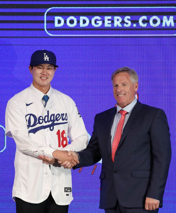 메이저리그(MLB) LA 다저스와 계약한 장현석이 14일 오후 서울 용산구 드래곤시티호텔에서 열린 입단 기자회견에서 유니폼과 모자를 착용한 뒤 존 디블 다저스 태평양 지역 스카우팅 디렉터와 함께 기념촬영을 하고 있다. [사진=뉴시스]