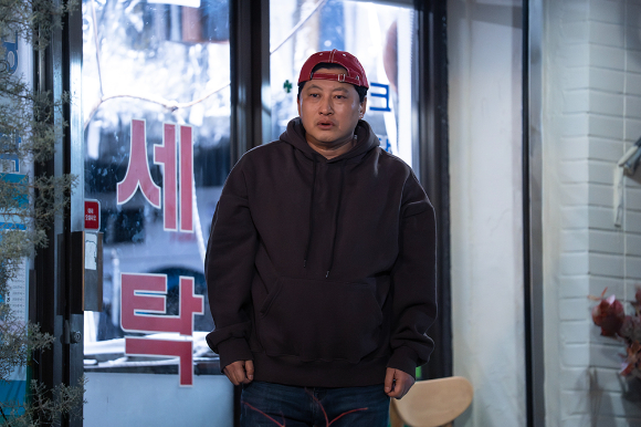 '김부장'에서 세탁소 임씨(임호원) 역을 맡은 배우 박진우가 꽃다발을 들고 기념 사진을 촬영하고 있다. [사진= SBS, NKMFILM]