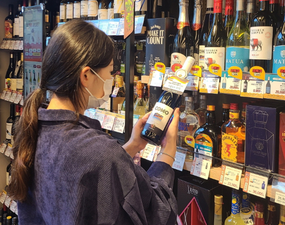 고객이 이마트24 매장에서 와인 상품을 살펴보고 있다. [사진=이마트24]