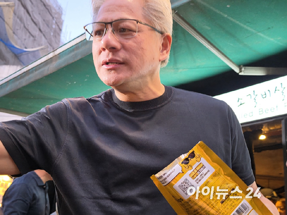 최태원 SK그룹 회장(왼쪽)과 젠슨 황 엔비디아 최고경영자(CEO)가 5일 서울 마포구 홍대 삼겹살집 '형님저요' 앞에서 SK하이닉스 HBM(고대역폭메모리) 과자칩을 들고 시민들과 소통하고 있다. [사진=정유림 기자]