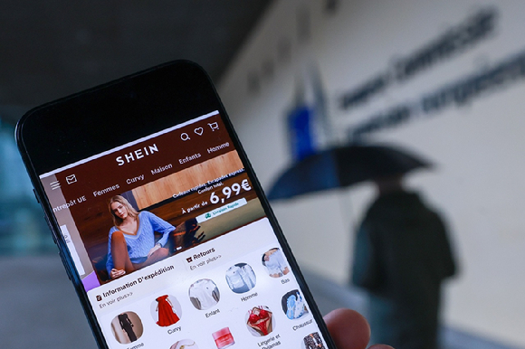 벨기에에 걸린 쉬인 광고와 쉬인 앱 [사진=EPA/연합뉴스]