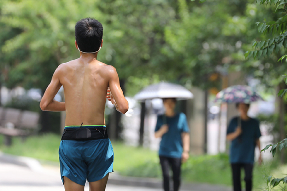 서울지역에 폭염 경보가 발령된 4일 오후 서울 여의도공원에서 한 시민이 옷을 벗고 러닝을 하고 있다. [사진=뉴시스]