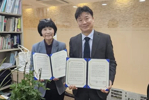 지난 12일 한국열린사이버대학교와 세계기후변화상황실이 MOU를 맺고, 양 기관 대표가 협약서를 들어보이고 있다. [사진=한국열린사이버대학교]