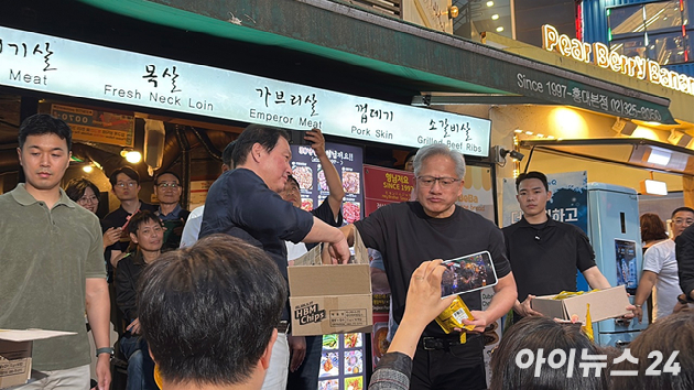 최태원 SK그룹 회장(왼쪽)과 젠슨 황 엔비디아 최고경영자(CEO)가 서울 마포구 홍대 삼겹살집 '형님저요' 앞에서 SK하이닉스 HBM(고대역폭메모리) 과자칩을 들고 시민들과 소통하고 있다. [사진=정유림 기자]