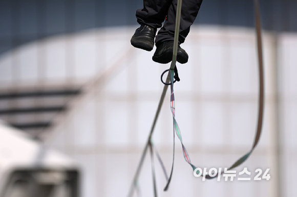 세계적인 슬랙라인 선수 얀 루스(Jaan Roose)가 1일 서울 광화문 사거리 상공 120m 높이에서 '레드불 서울 줄타기' 퍼포먼스를 선보이고 있다. [사진=정소희 기자]