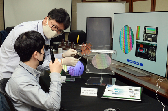 ETRI 연구진이 저온공정이 가능한 포토레지스트 소재로 OLED 디스플레이용 기판을 만들어 설명하고 있는 모습 [사진=ETRI]