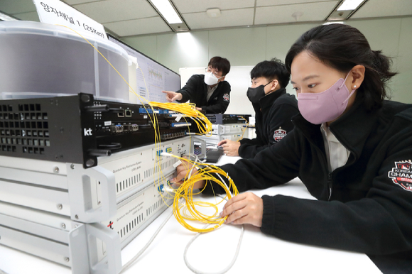 KT 융합기술원 연구원들이 양자 채널 일원화 장비 시스템을 모니터링하는 모습. [사진=KT]