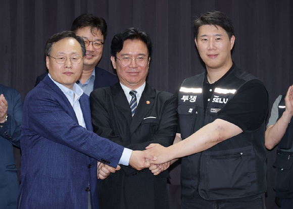 20일 경기도 수원시 장안구 경기고용노동청에서 열린 삼성전자 임금협상을 마친 후 여명구 삼성전자 DS(디바이스솔루션&middot;반도체 사업 담당) 피플팀장과 최승호 삼성그룹 초기업노동조합 삼성전자지부 위원장이 잠정 합의안에 서명한 후 김영훈 고용노동부 장관과 손을 맞잡고 있다. 2026.5.20 [공동취재] [사진=연합뉴스]