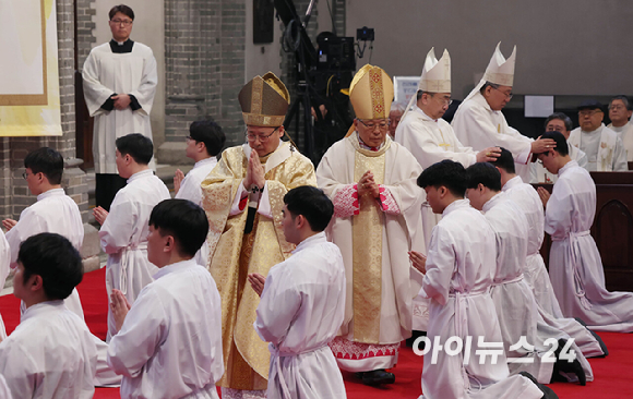 1일 서울 중구 명동대성당에서 열린 2024년 천주교 서울대교구 부제 서품식에서 부제 수품자들이 정순택 대주교를 비롯한 교구 주교·사제단에게 안수받고 있다. [사진=사진공동취재단]