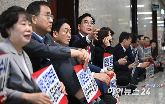 국민의힘 송언석 원내대표와 의원들이 3일 서울 여의도 국회에서 긴급의원총회 및 특검 압수수색 규탄대회를 마친 뒤 원내대표실 앞에서 압수수색 대비 연좌농성을 하고 있다. [사진=곽영래 기자]