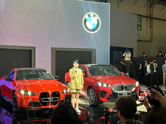 주양예 BMW 코리아 브랜드 총괄 본부장이 뉴 M4, 올 뉴 iX2 사이에서 발표를 진행하고 있다. [사진=홍성효 기자]