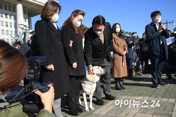 윤석열 국민의힘 대선 후보가 13일 오전 서울 여의도 국회에서 열린 중앙선대위 장애인본부 전국 릴레이정책투어 '장문현답(장애인 문제의 답은 현장에 있다)' 출정식에서 김예지 국민의힘 의원의 안내견 조이를 쓰다듬고 있다. [사진=국회사진취재단]