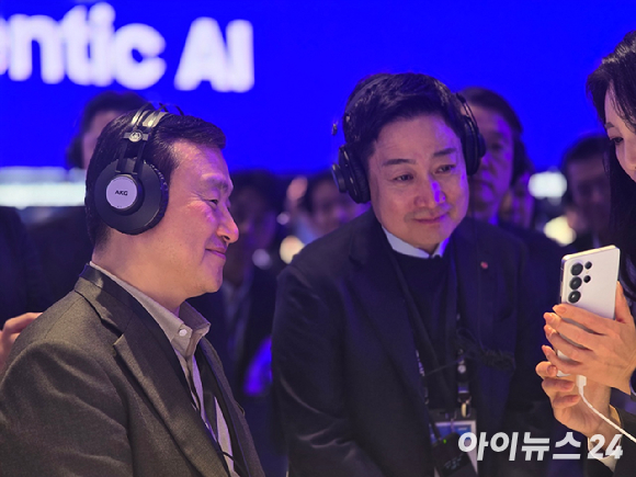 홍범식 LG유플러스 대표(우측)가 2일(현지시간) 스페인 바르셀로나 피아 그란비아 내 삼성전자 MWC 2026 전시관에서 노태문 삼성전자 사장과 만난 뒤 부스 관계자로부터 전시관 설명을 듣고 있다. [사진=안세준 기자]