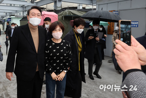 윤석열 대통령 당선인이 14일 당선 이후 첫 외부 공식일정으로 서울 남대문 시장을 찾아 한 상인과 기념촬영을 하고 있다. [사진=국회사진취재단]