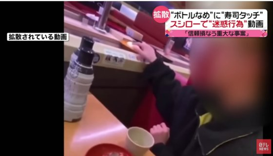일본에서 한 남성이 침을 묻힌 손가락으로 레일 위 초밥을 만지고 있는 모습이다. [사진=유튜브 니혼테레비 캡처]