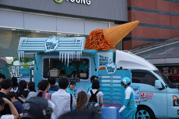 맵탱 쿨스파이시 비빔면을 아이스크림 콘에 담아 제공하는 '쿨비빔콘' 푸드트럭 앞에 시민들이 줄을 서 기다리고 있다. [사진=삼양식품]