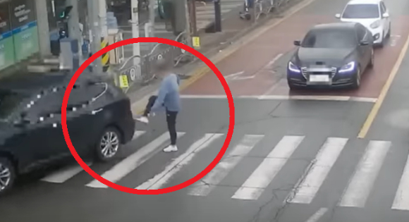 보행자 신호에 길을 건너던 한 시민이 신호를 무시한 채 자신의 앞을 지나가는 차량을 발로 찼다. 위 사진은 보행자 A씨가 당시 차량을 발로 차는 모습. [사진=유튜브 '한문철TV']