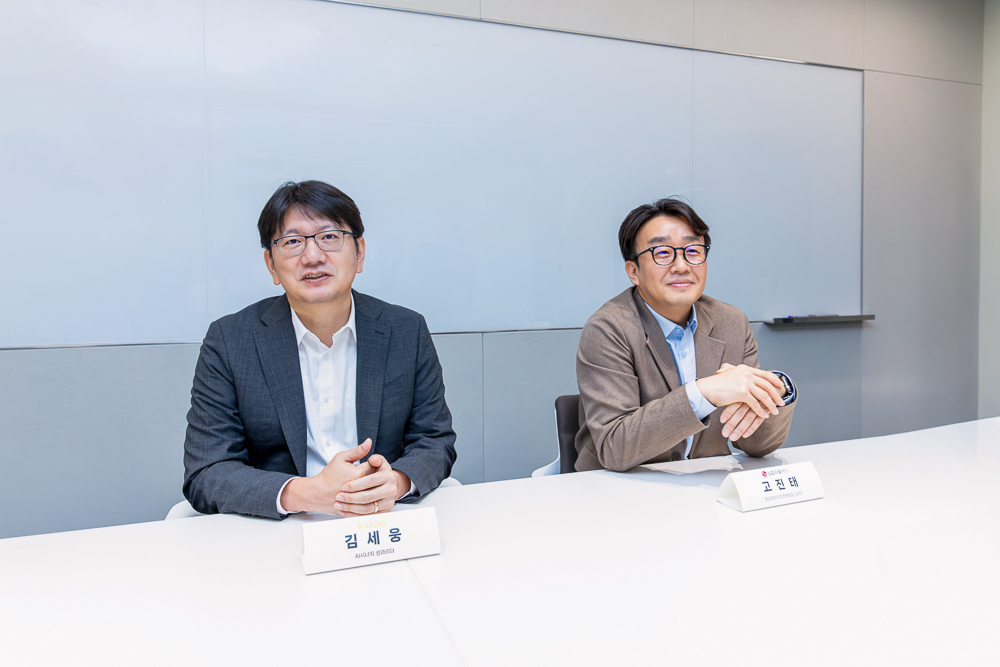 과학기술정보통신부의 대국민 AI 서비스 프로젝트 '모두의 AI' 사업 수행자로 선정된 카카오의 김세웅 인공지능(AI) 시너지 성과리더(부사장&middot;왼쪽)와 고진태 LG유플러스 엔터프라이즈전략담당(상무)이 사진을 찍고 있다. [사진=카카오]