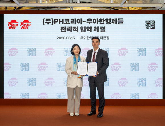 김지훈(오른쪽) 우아한형제들 사업부문장과 김정은 PH코리아 대표가 지난 15일 서울 송파구 우아한형제들 본사에서 전략적 업무 협약(MOU)을 체결한 뒤 기념 촬영을 하고 있다. [사진=우아한형제들]