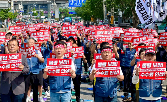 전국택배노동조합 우체국본부가 26일 오전 서울 광진구 동서울우편집중국 앞에서 6월 총력투쟁 선포 결의대회를 열고 물량 보장, 수수료 인상 등을 촉구하며 구호를 외치고 있다. [사진=택배노조]