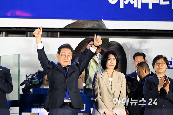 당선이 확실시된 이재명 더불어민주당 대통령 후보와 김혜경 여사가 4일 오전 서울 여의도 국회 앞에서 열린 국민 개표방송 행사에서 지지자들의 환호에 손을 들어 화답하고 있다. [사진=곽영래 기자]