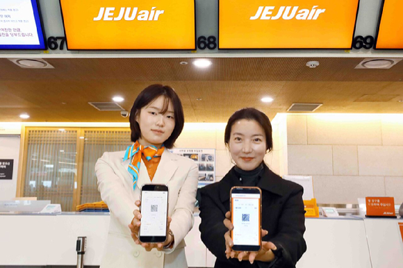 김포공항 국내선 청사 제주항공 카운터에서 제이에이에스(JAS) 직원과 탑승객이 발급 받은 모바일 탑승권을 들어 보이고 있다. [사진=제주항공]