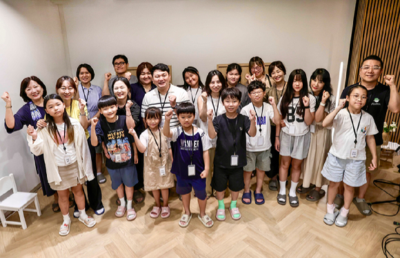 KTis 임직원과 자녀가 함께 동화책 낭독 봉사활동을 위한 단체사진을 촬영하고 있다. [사진=KTis]