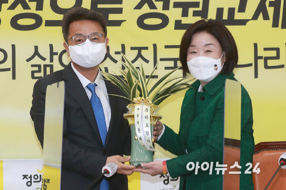 심상정 정의당 대선후보(오른쪽)과 이철희 청와대 정무수석이 16일 오후 서울 여의도 국회에서 문재인 대통령의 축하 난을 들고 기념촬영을 하고 있다. [사진=정소희 기자]