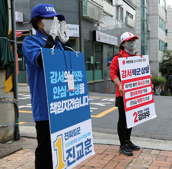 지난 8일 서울 강서구의 한 교회 앞에서 진교훈 더불어민주당 강서구청장 후보 선거운동원(왼쪽 앞)과 김태우 국민의힘 강서구청장 후보 선거운동원이 지지를 호소하고 있다. [사진=뉴시스]