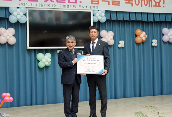 윤송관 우도면 연합청년회 회장(오른쪽)이 이강식 교장 선생에게 장학 증서를 기탁하고 있다. [사진=제주특별자치도교육청]