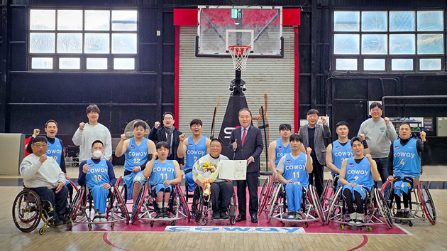 지난 5일 안병태 한국휠체어농구연맹 총재가 코웨이 블루휠스 연습구장을 찾아 김영무 감독에게 표창과 꽃다발을 전달했다. [사진=코웨이]