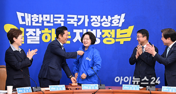 더불어민주당 정청래 대표가 13일 서울 여의도 국회에서 열린 최고위원회의에 앞서 추미애 경기도지사 후보에게 당 점퍼를 입혀주고 있다. [사진=곽영래 기자]