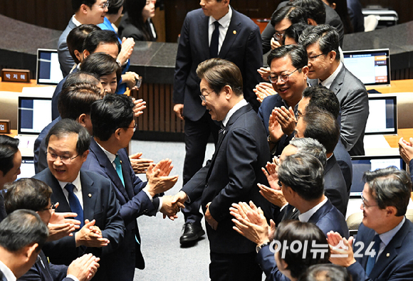 이재명 대통령이 26일 국회에서 열린 본회의에서 추가경정예산 시정연설을 하기 위해 입장하며 의원들과 인사를 하고 있다. [사진=국회사진기자단]
