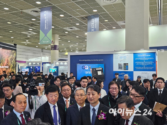 안덕근 산업통상자원부 등 주요 인사 18명이 12일 서울 강남구 코엑스에서 열린 일렉스(ELECS)코리아 2025 전시회에 마련된 부스 앞에서 설명을 듣고 있다. [사진=설재윤 기자]