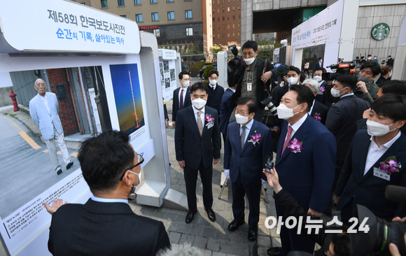 윤석열 대통령 당선인이 4일 오전 서울 중구 프레스센터광장에서 열린 제58회 한국보도사진전 개막식에 참석해 대상에 선정된 '광주 재판날 출석 않고 동네 산책하는 전두환' 사진을 보고 있다. [사진=인수위사진기자단]