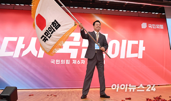 국민의힘 장동혁 신임 당대표가 26일 오전 서울 여의도 국회 도서관에서 열린 제6차 전당대회 결선에서 당기를 흔들고 있다. [사진=곽영래 기자]