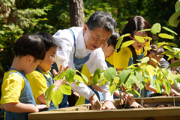 남성현 산림청장이 13일 충북 청주시 구룡유아숲체험원에서 어린이들과 자생식물 꽃밭 가꾸기를 하고 있다. [사진=산림청]