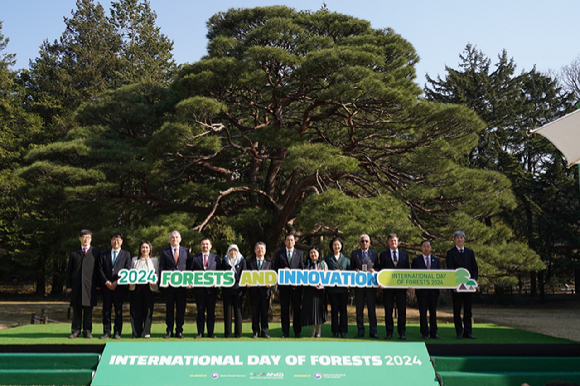 21일 서울 국립산림과학원에서 열린 '2024 세계산림의 날 기념행사'에서 남성현 산림청장(왼쪽에서 일곱번째), 쉥야요 탕 FAO한국사무소장(오른쪽에서 두번째), 아시아산림협력기구(AFoCO) 사무차장, 아시아산림협력기구 회원국 대사, 외교부 관계자 등이 메시지를 담은 손팻말을 들고 기념촬영을 하고 있다. [사진=산림청]