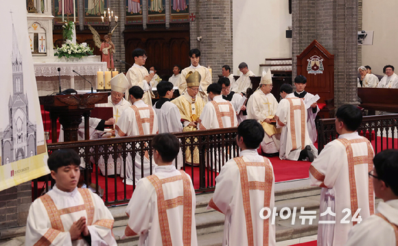 1일 서울 중구 명동대성당에서 열린 2024년 천주교 서울대교구 부제 서품식에서 정순택 대주교를 비롯한 교구 주교·사제단이 부제 수품자들에게 복음집을 수여하고 있다. [사진= 사진공동취재단]