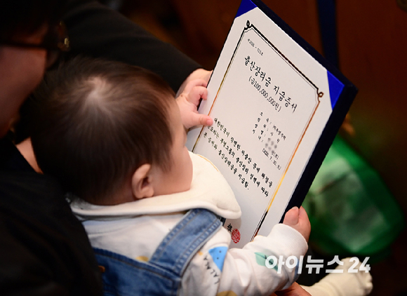 이중근 부영그룹 회장이 5일 서울 중구 세종대로 부영태평빌딩에서 열린 2026년 부영그룹 시무식 및 출산장려지원 행사에서 출산장려지원금 혜택을 받은 직원 자녀에게 인사하고 있다. [사진=정소희 기자]