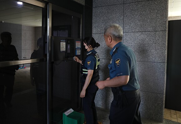 출동 경찰관이 공동현관 카드로 출입문을 열고 있다. [사진=충북경찰청]