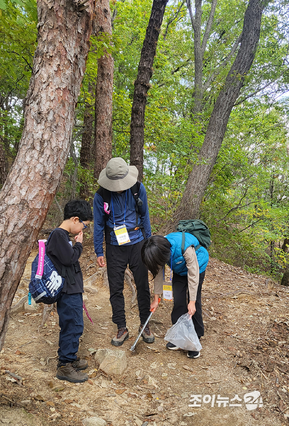25일 서울 강북구 우이동 북한산국립공원 일대에서 열린 '브브걸 민영과 함께 하는 팬트레킹-제12회 희망찾기 등산&middot;트레킹 교실'에서 한 가족이 플로깅(쓰레기를 주우며 트레킹하는 친환경 활동)을 하면서 산행을 즐기고 있다. [사진=정소희 기자]