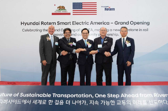 이용배(왼쪽에서 세 번째) 현대로템 대표이사 사장이 제스 몬테스(두 번째) LA메트로 철도차량 사업 총괄과 마이크 퓨트렐(첫 번째) 리버사이드시 행정시장, 척 콘더(네 번째) 리버사이드시 시의원, 김영완(다섯 번째) 주미 LA 총영사와 18일(현지시간) 미국 캘리포니아주 리버사이드시에서 진행된 &lsquo;현대로템 스마트 일렉트릭 아메리카(HRSEA)&rsquo;전장품 공장 준공식에서 기념촬영을 하고 있다. [사진=현대로템]